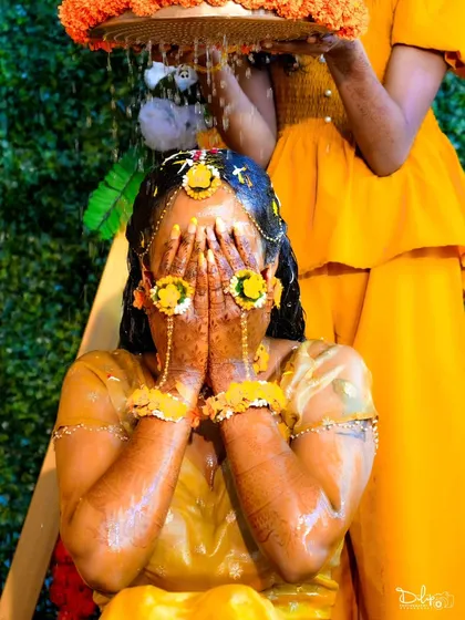 An emotional and beautiful moment as the bride is showered with water and turmeric during her Haldi ceremony. These are the candid shots that tell the real story.