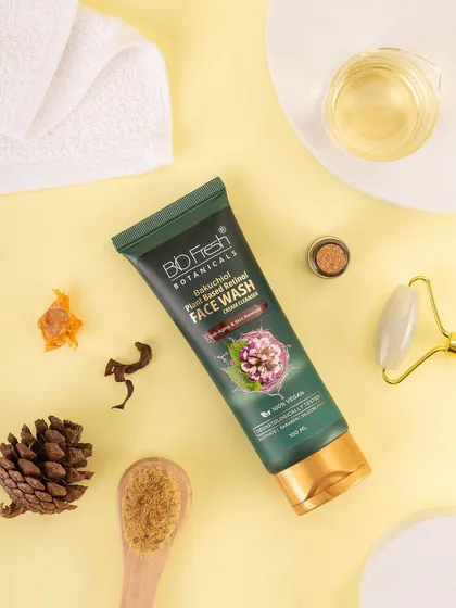 A styled flat lay of Biofresh Botanicals' face wash with skincare tools and natural elements. This top-down view shows the product as part of a complete self-care ritual.