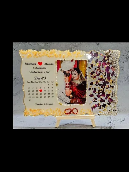 This is a perfect example of how we can combine memories. I preserved varmala petals on one side and created a custom calendar marking the wedding date on the other, all framing a beautiful wedding photo. It’s a functional and sentimental piece for your home.