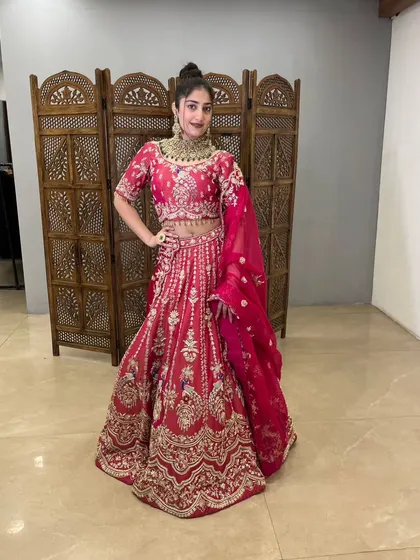 A full view of the pink lehenga, showing its rich color and intricate gold embroidery.