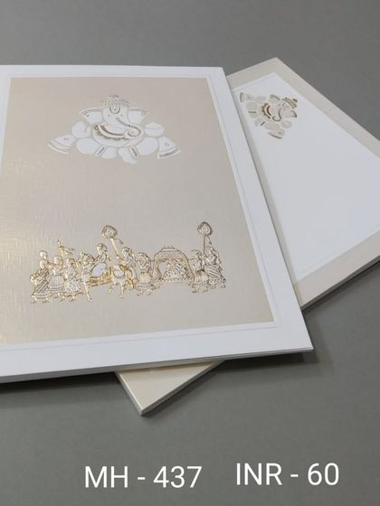 This off-white card features a subtle embossed Ganesha at the top with a traditional baraat scene below. The design is minimalist yet deeply rooted in wedding traditions.