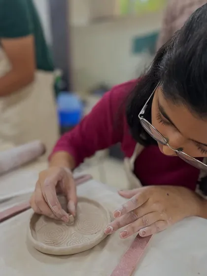 Using a small tool to add texture to a hand-built trinket dish. It's these small details that make each piece special.