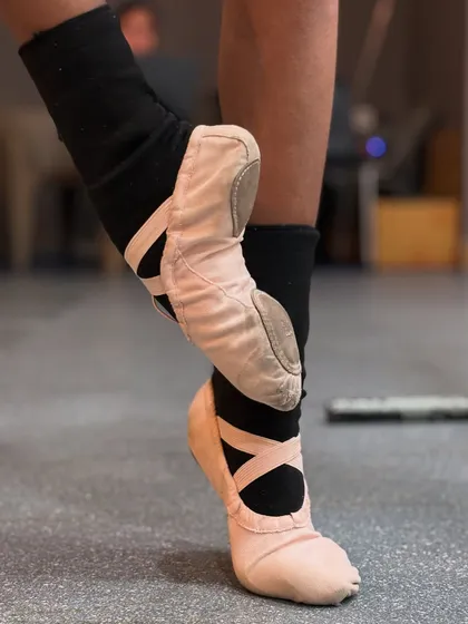 A ballerina's feet tell a story of strength and dedication. These close ups show both soft ballet slippers and hard pointe shoes, representing the different stages of a dancer's journey.