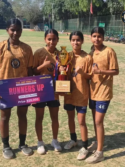 Four of our players holding the runners-up trophy and prize from the JMF Pink Cup. A proud moment reflecting their hard work and team effort.