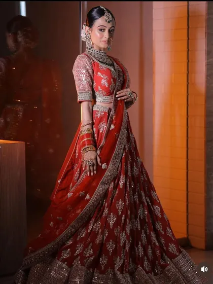 A full-length and a close-up shot of a bride in a stunning red lehenga. This provides a complete view of the outfit and the intricate makeup and jewellery.
