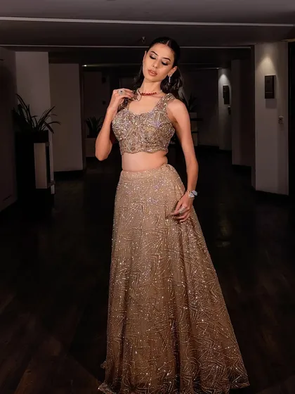 A full-length view of this stunning modern bridal lehenga. The shimmering gold fabric and the contemporary design call for equally glamorous makeup.
