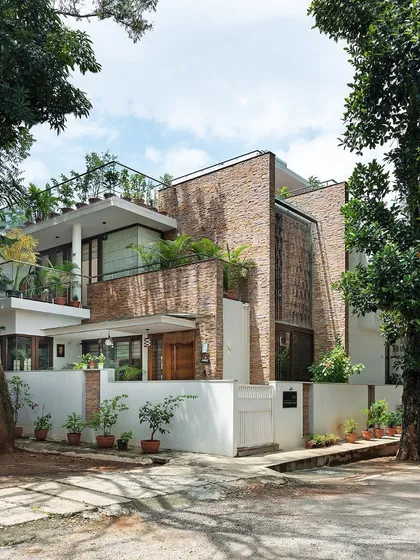 This is the exterior of our Twin Courtyard House. The facade is a composition of natural stone cladding and carefully placed greenery, demonstrating how landscape design can be integral to the architectural identity of a home.