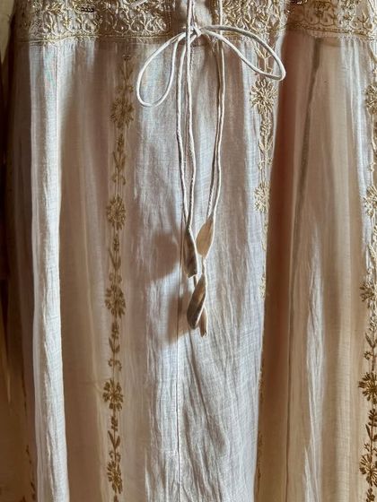 A detail shot of the lower part of the Anarkali, showing the delicate embroidery that continues down the length of the garment.