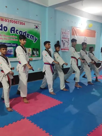 Students lined up in a 'Juchum Seogi' (horse riding stance) while practicing a middle punch. This stance builds lower body strength.