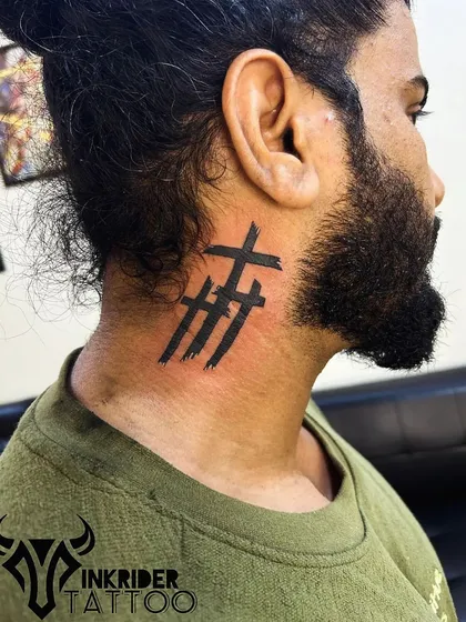 Three crosses in a bold, brush-stroke style on the neck. This design gives a modern and raw feel to a classic symbol.