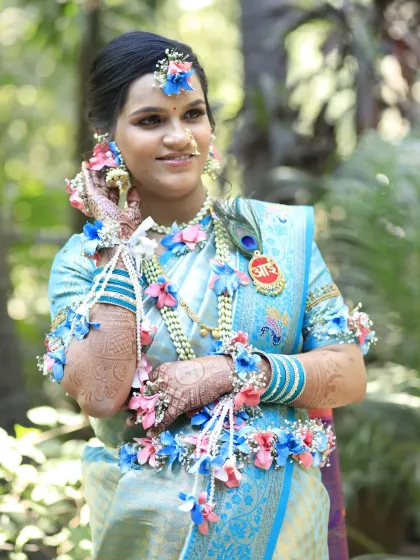 A bright and happy portrait for a baby shower. The client's smile shines, complemented by a makeup look that is both traditional and fresh, along with beautiful, handcrafted floral jewelry.