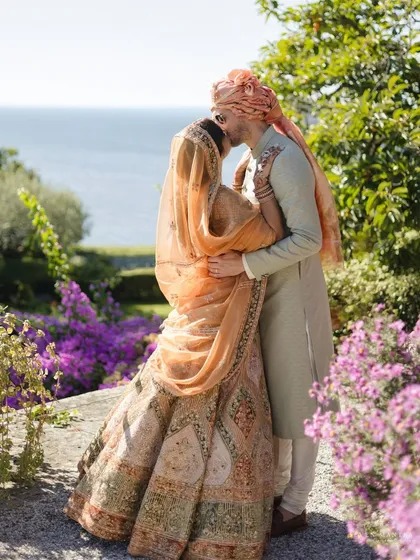 A stolen kiss amidst the bougainvillea. For this destination wedding in Italy, I used the natural landscape as our canvas, styling this intimate moment with the vibrant purple flowers and the sparkling sea in the background.