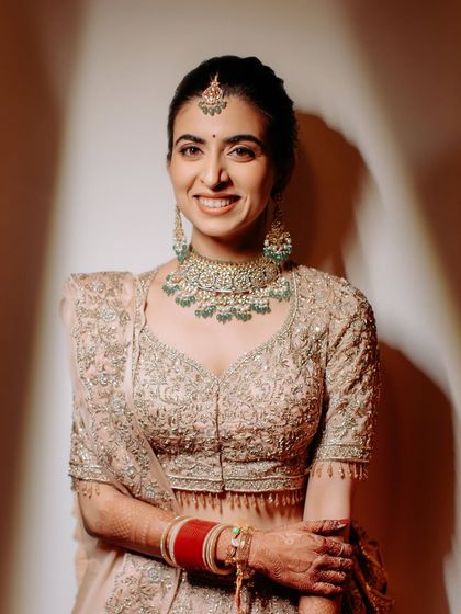 A stunning portrait. The lighting highlights the soft glow of her skin and the intricate details of her peach-golden outfit.