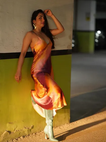 A full-length shot showing the unique combination of the elegant dress and bold boots.