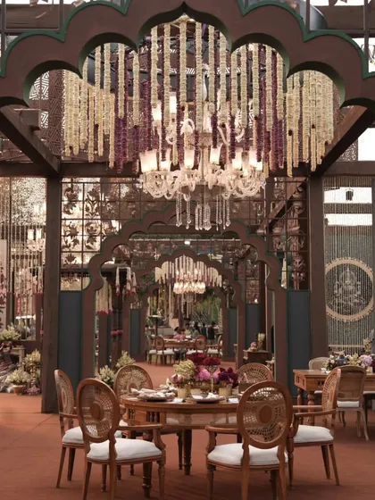 Another view of the dining area, highlighting the interplay between the floral chandeliers, the traditional arches, and the elegant table settings.