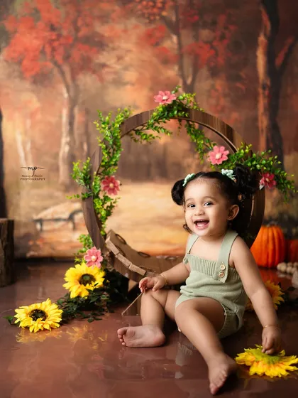 A radiant smile from a little girl in an autumn-themed woodland setting. Her joy is absolutely contagious in this beautiful milestone portrait.