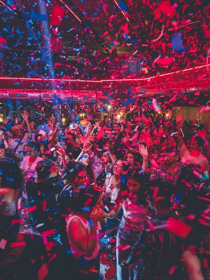 A massive red and blue confetti explosion over the entire club. This is the peak moment of the night, a memory everyone takes home.
