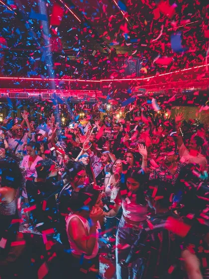 A massive red and blue confetti explosion over the entire club. This is the peak moment of the night, a memory everyone takes home.
