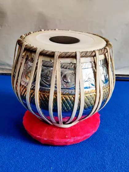 A close-up of a delivered 3kg pittal baya (left-hand drum). This designer piece features intricate chrome and brass work, combining beautiful aesthetics with professional sound quality.