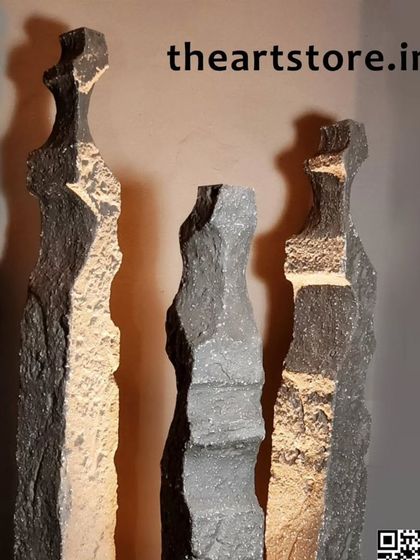 Tall, slender sculptures with a rough, natural stone texture and gold accents, adding a touch of raw elegance.