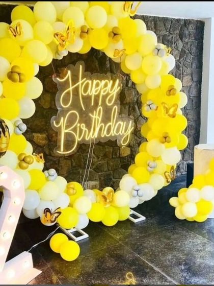 Sunshine and happiness in one beautiful setup. This bright yellow balloon ring, accented with butterfly details and a '2' marquee number, is perfect for a cheerful and vibrant second birthday party.