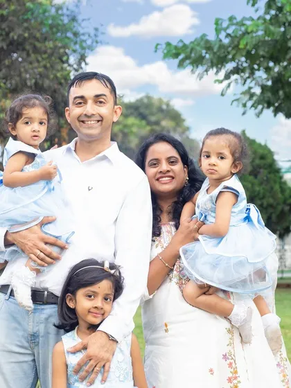 A lovely family enjoying a day in the park. The coordinated outfits and the beautiful natural light make this a perfect outdoor family photo.