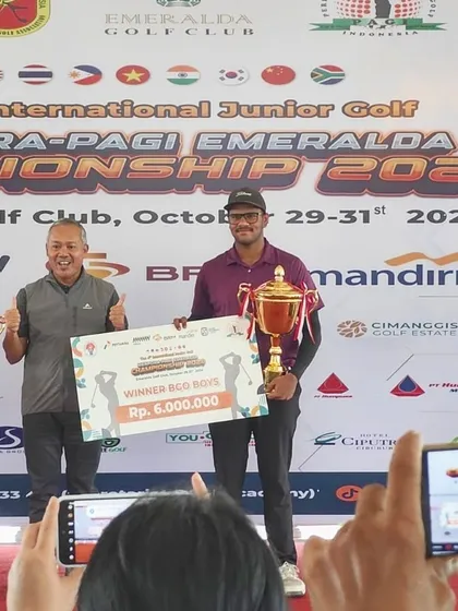 Harman on stage receiving his winner's trophy and prize at the International Junior Golf Championship in Jakarta, Indonesia.