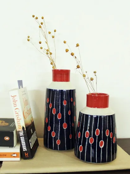 Styled on a bookshelf, the Dew Drops vases show how functional art can elevate your home decor. Each vase is wheel-thrown and painted by hand, making it a unique accent piece.
