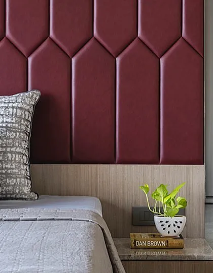 A detail of the geometric red headboard and the custom nightstand, showing the clean lines and luxurious materials used in the 'Aria Residence'.
