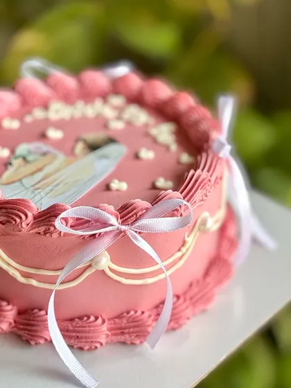 A side angle showing the intricate piping and the way the white ribbons are gracefully tied around the cake, adding a soft, romantic touch.