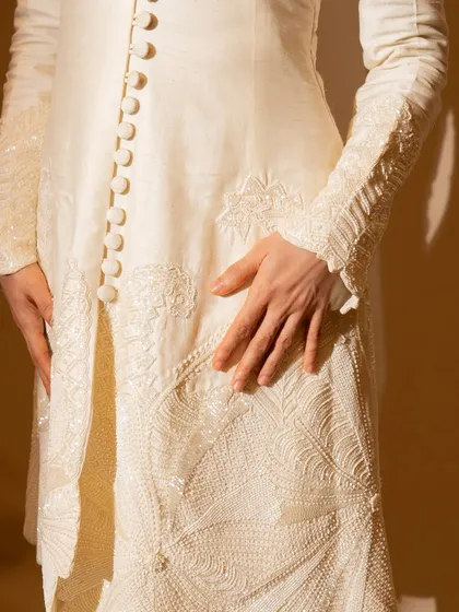 This ivory kurta and flared pants set on Nushrratt Bharuccha is all about classic elegance. The delicate embroidery and button details make it a timeless piece for any special occasion.