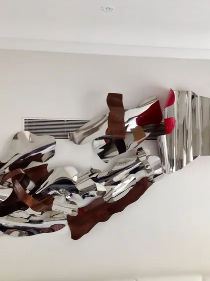 Another view of the large-scale abstract wall sculpture, highlighting its different materials and textures.