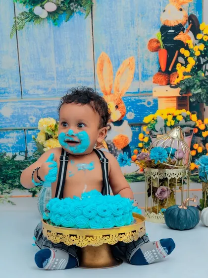 Pure joy and a face full of cake! This little boy is having a blast with his blue birthday cake. Our cake smash sessions are designed to be fun, messy, and absolutely unforgettable.
