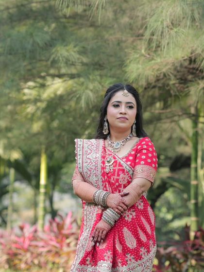 A portrait of the bride against a backdrop of trees. Her traditional attire and elegant makeup make for a timeless picture.