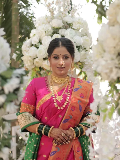 Our stunning Maharashtrian bride in her royal Nauvari look. Grace, tradition, and a beautiful smile, all in one frame against a backdrop of white flowers.
