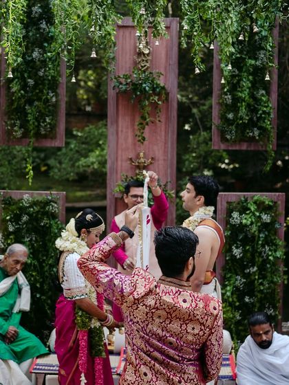 Family members participate in the wedding rituals, wrapping the couple in a traditional cloth to symbolize their union.