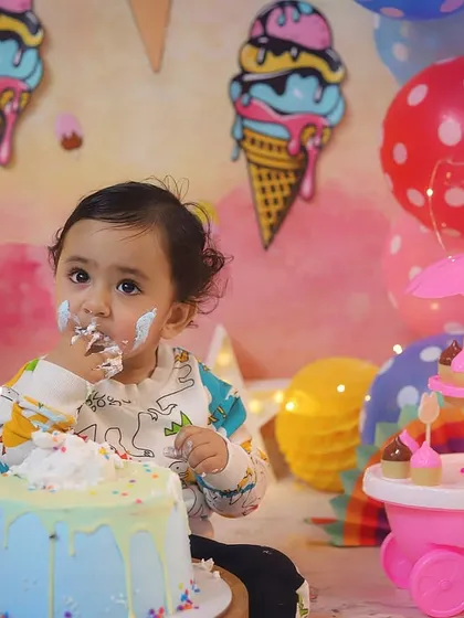 The best part of a cake smash is getting to eat the cake! This close-up shot captures the pure delight of his first taste of birthday cake.