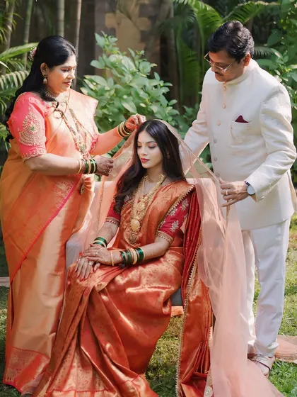 A touching moment with the bride and her parents as they place the veil on her head, a symbol of their blessings.