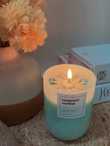 The cozy glow of our Summer Sorbet candle. It's the perfect companion for a relaxing evening with a good book.
