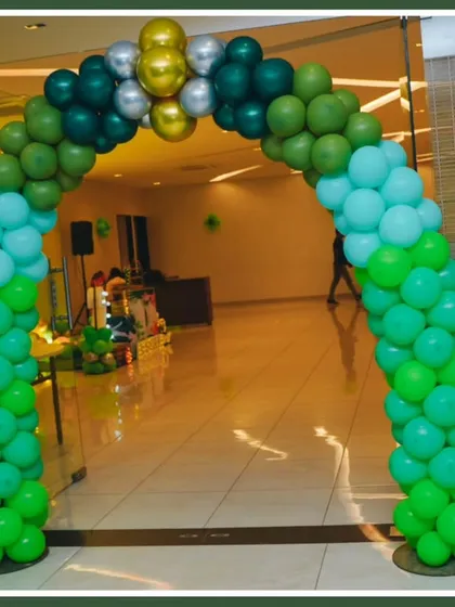 A welcoming balloon arch in shades of green for a jungle-themed party, setting the tone for the celebration.