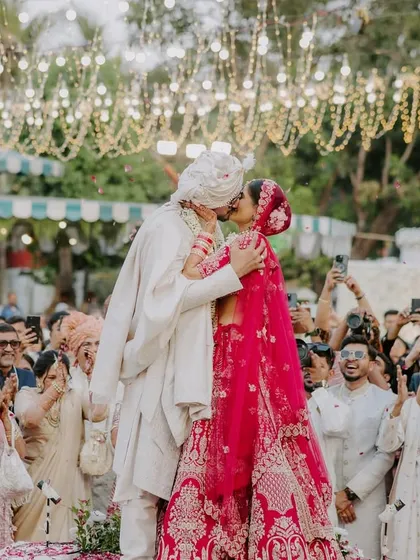 The first kiss as husband and wife, surrounded by cheering family and friends. This is a pinnacle moment, filled with emotion and celebration.