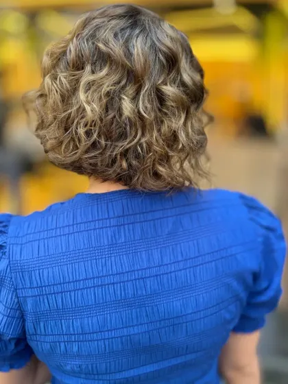 The back of a chic, curly bob with blonde highlights. This shows how color can make curls pop and add amazing texture.
