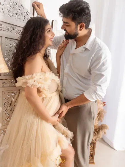 A bright and airy couple's portrait with a bohemian feel. The couple shares a loving gaze, surrounded by natural textures and soft lighting in the studio.