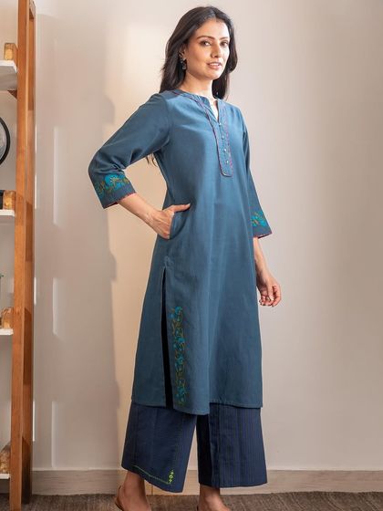 A full-length view of our Haveli Crewel Blue Kurta, styled with matching pants. The straight fit and side pockets make it a practical and elegant choice for everyday wear.