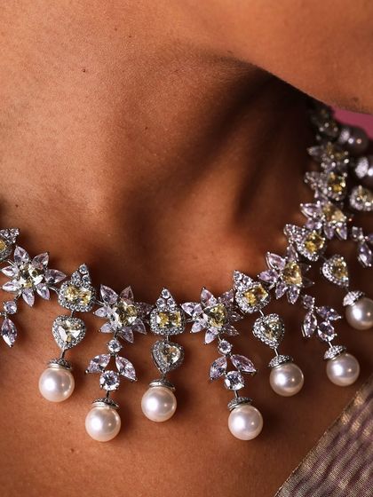 A close-up of the Yellow Sapphire and Pearl necklace as worn, showing the radiant glow of the gems against the skin. This piece is designed to make a statement of pure elegance.