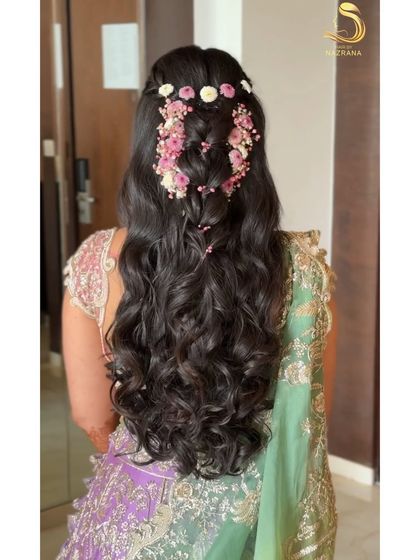 A stunning half-up style with a cascading floral braid, perfect for a Mehendi.