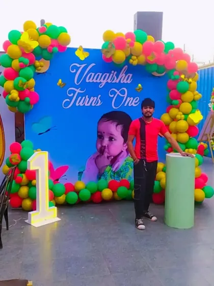 Here I am with the completed first birthday setup, showing the scale of the backdrop and balloon frame.