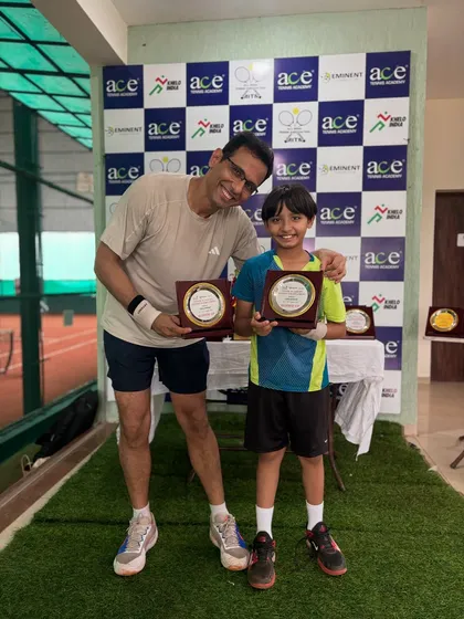 A proud moment for a father and son, both players, showing off their awards at the Ace Tennis Academy tournament.