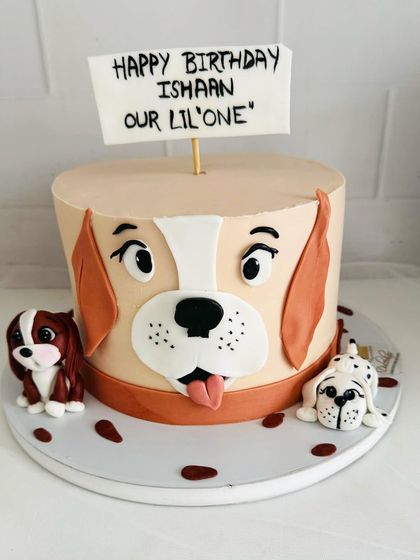 An adorable dog-themed cake for a little one's birthday, complete with cute fondant puppy figures.