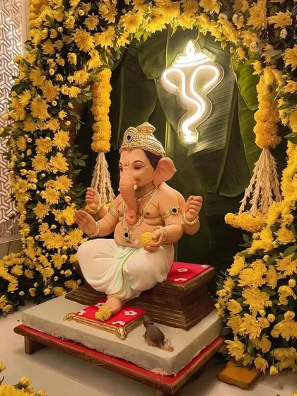 For festive occasions like Ganesh Chaturthi, I create decor that is both devotional and beautiful. This installation features a Ganesha idol framed by a dense arch of yellow marigolds and a modern neon sign, blending tradition with contemporary design.